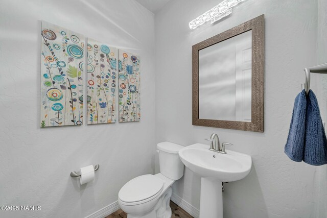 bathroom with baseboards and toilet