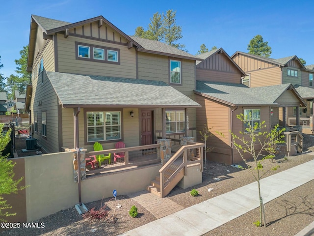 craftsman-style home featuring covered porch, board and batten siding, and roof with shingles