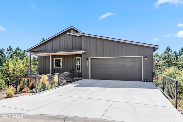 view of front of home with a garage, driveway, a shingled roof, and fence