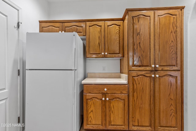 1401 N 4th St Unit 228, Flagstaff, AZ 86004 - kitchen featuring freestanding refrigerator, brown cabinetry, and light countertops
