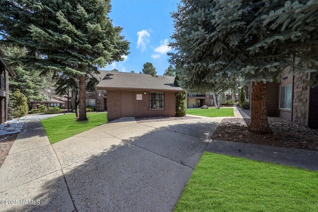 1200 S Riordan Ranch St Unit 36, Flagstaff, AZ 86001 - view of property exterior featuring a lawn and roof with shingles