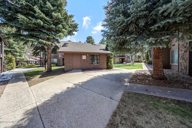 1200 S Riordan Ranch St Unit 36, Flagstaff, AZ 86001 - view of side of home featuring a yard and roof with shingles