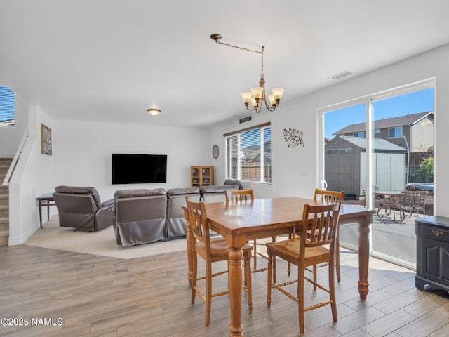 4580 Centaurus Rd, Bellemont, AZ 86015 - dining area featuring stairway, a chandelier, light wood finished floors, and plenty of natural light