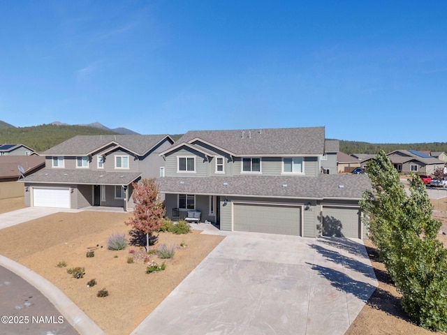 4580 Centaurus Rd, Bellemont, AZ 86015 - view of front of house with concrete driveway, an attached garage, a mountain view, roof with shingles, and a residential view