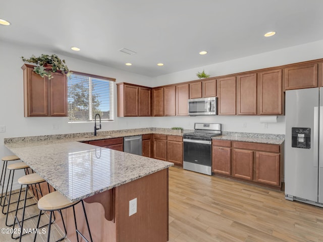 4580 Centaurus Rd, Bellemont, AZ 86015 - kitchen featuring stainless steel appliances, a sink, brown cabinetry, and a breakfast bar area
