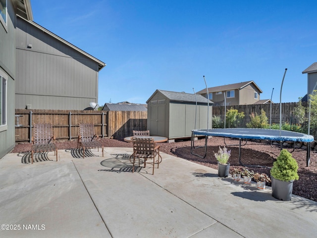4580 Centaurus Rd, Bellemont, AZ 86015 - view of patio / terrace with a trampoline, an outbuilding, a shed, and a fenced backyard