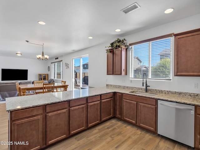 4580 Centaurus Rd, Bellemont, AZ 86015 - kitchen featuring visible vents, stainless steel dishwasher, a sink, a peninsula, and light wood-style flooring