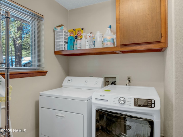 laundry room featuring washing machine and dryer and cabinet space