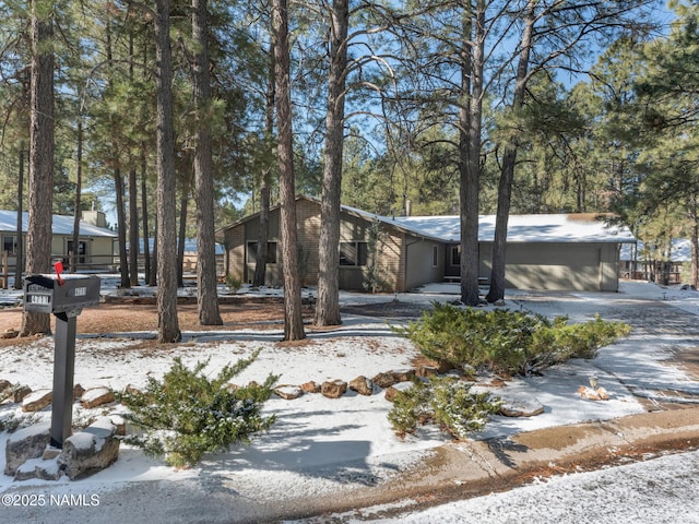 mid-century inspired home with driveway and brick siding