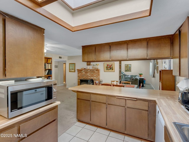 kitchen with light countertops, open floor plan, and stainless steel microwave