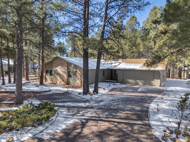 view of front of home with a garage, decorative driveway, and brick siding