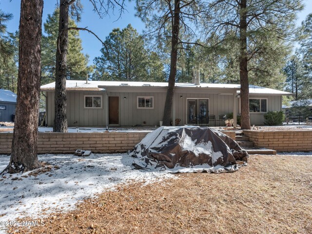 view of front of house with board and batten siding and a patio area