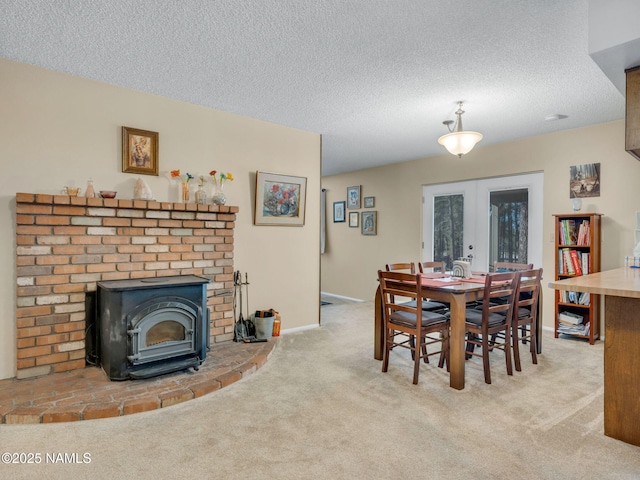 dining area featuring a textured ceiling, baseboards, french doors, carpet, and a wood stove