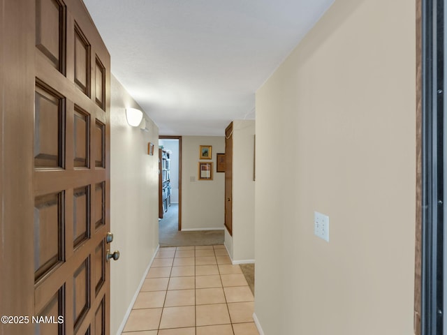 corridor with baseboards and light tile patterned floors