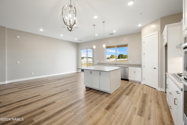 kitchen featuring white cabinets, a center island, pendant lighting, and light hardwood / wood-style floors