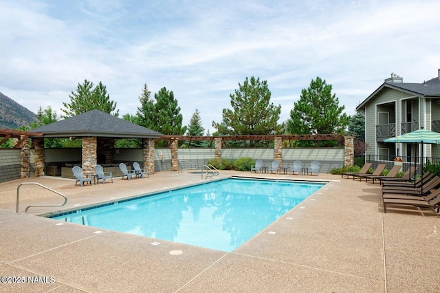 view of swimming pool featuring a gazebo, a patio, and exterior bar