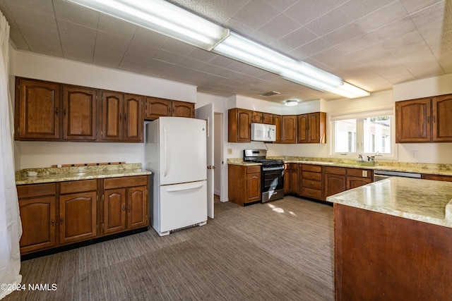 kitchen featuring sink, dark colored carpet, and appliances with stainless steel finishes