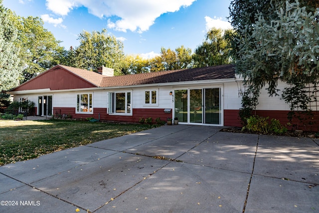 rear view of property featuring a lawn