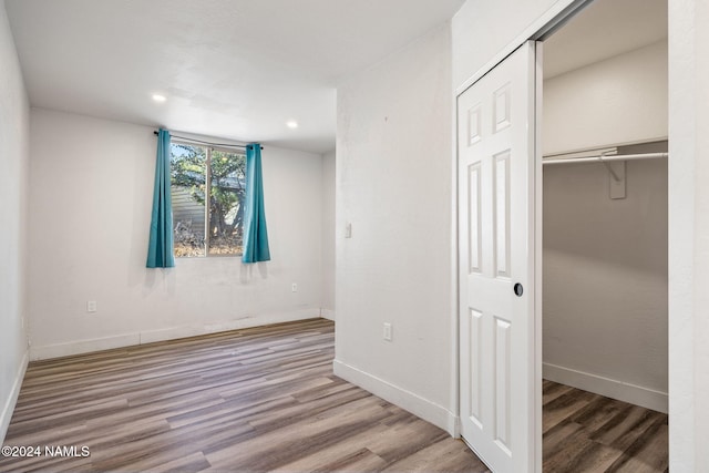 unfurnished bedroom with wood-type flooring and a closet