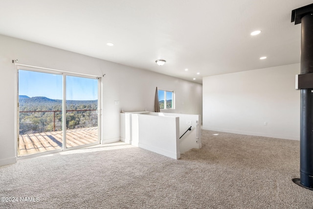 unfurnished living room with a mountain view and carpet flooring