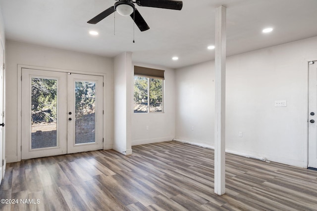 empty room featuring ceiling fan, hardwood / wood-style flooring, a wealth of natural light, and french doors