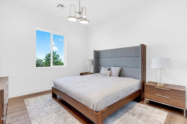 bedroom featuring light hardwood / wood-style flooring and a notable chandelier