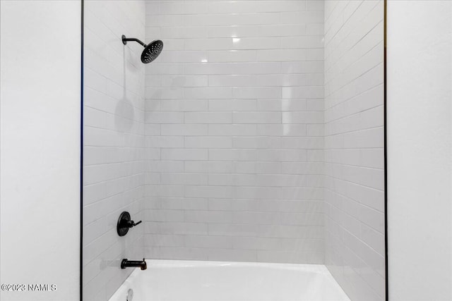 room details with tiled shower / bath combo