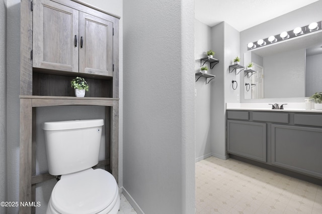 6437 N Conrad Ln, Flagstaff, AZ 86004 - bathroom with tile patterned floors, toilet, vanity, baseboards, and a textured wall