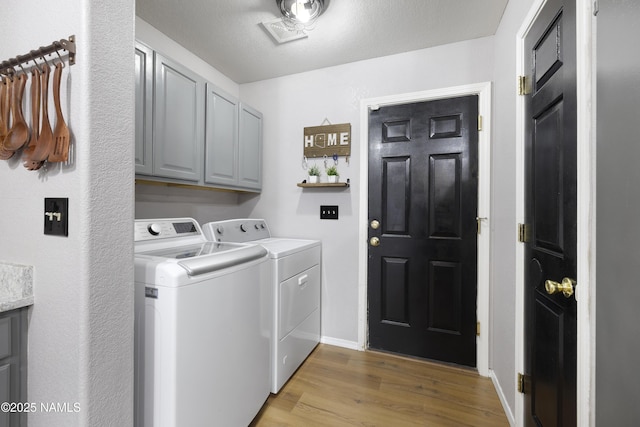6437 N Conrad Ln, Flagstaff, AZ 86004 - clothes washing area with cabinet space, washing machine and clothes dryer, light wood finished floors, and baseboards
