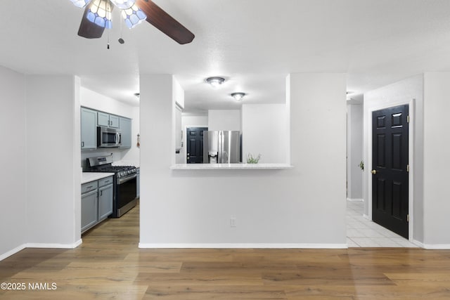 6437 N Conrad Ln, Flagstaff, AZ 86004 - kitchen featuring appliances with stainless steel finishes, a ceiling fan, light countertops, light wood-style flooring, and baseboards
