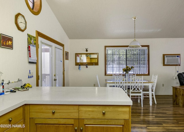 kitchen with lofted ceiling, a peninsula, light countertops, and a wall mounted AC