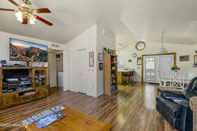 living area with lofted ceiling, visible vents, ceiling fan, wood finished floors, and baseboards