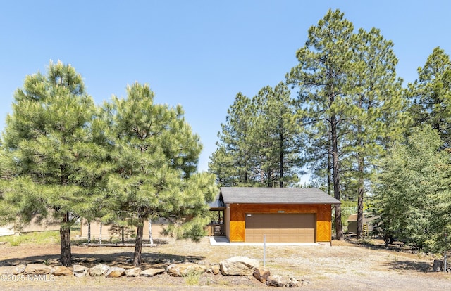 exterior space with dirt driveway and a garage