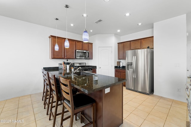 kitchen featuring stainless steel appliances, visible vents, a sink, a peninsula, and a kitchen breakfast bar