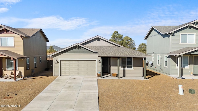 view of front of property featuring driveway, an attached garage, a shingled roof, and board and batten siding