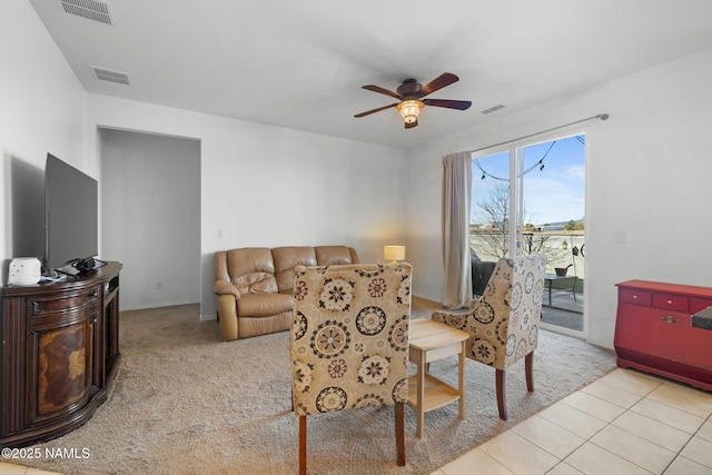 living room featuring light tile patterned floors, visible vents, and a ceiling fan