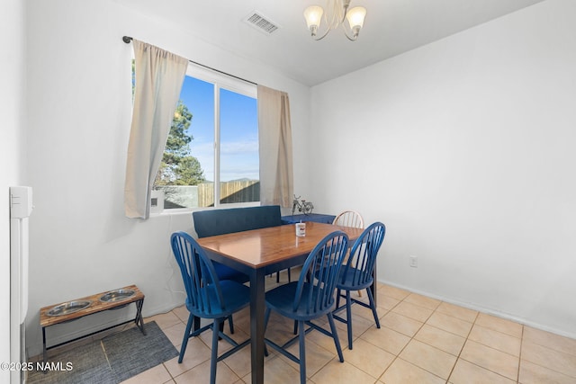 dining room with a chandelier, light tile patterned floors, and visible vents