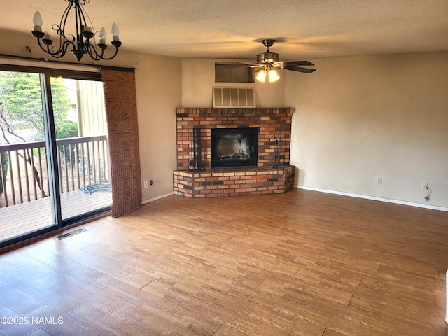 unfurnished living room featuring a textured ceiling, wood finished floors, and visible vents