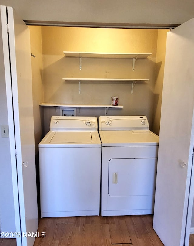 laundry room with washing machine and clothes dryer, laundry area, and dark wood-style floors