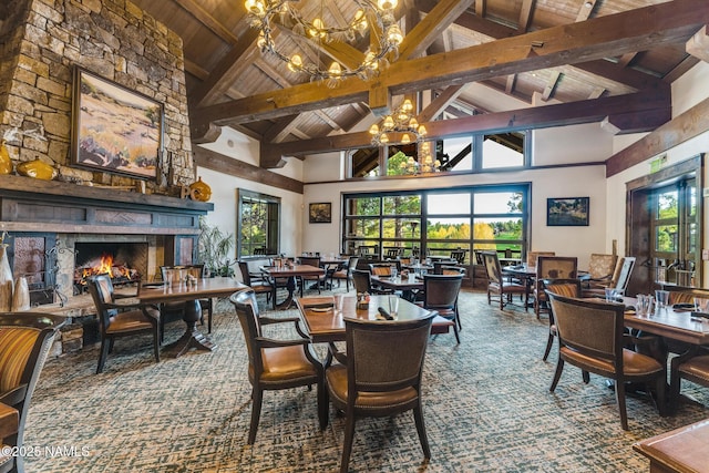 carpeted dining area with beam ceiling, a stone fireplace, wooden ceiling, high vaulted ceiling, and a notable chandelier