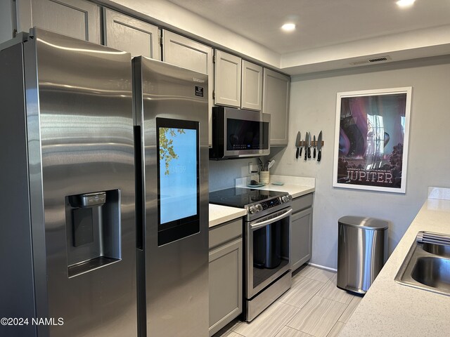 kitchen featuring sink, appliances with stainless steel finishes, and gray cabinets