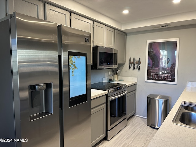 kitchen featuring sink, appliances with stainless steel finishes, and gray cabinets