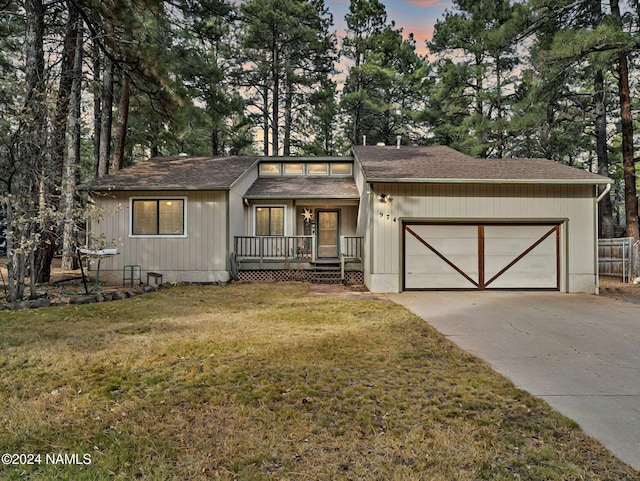 view of front of property with a garage and a yard