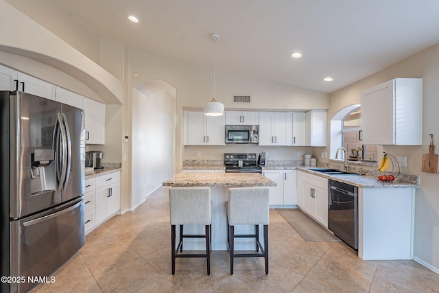 kitchen with decorative light fixtures, sink, white cabinets, a center island, and stainless steel appliances