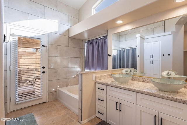 bathroom with tile patterned flooring, vanity, tile walls, and shower / tub combo