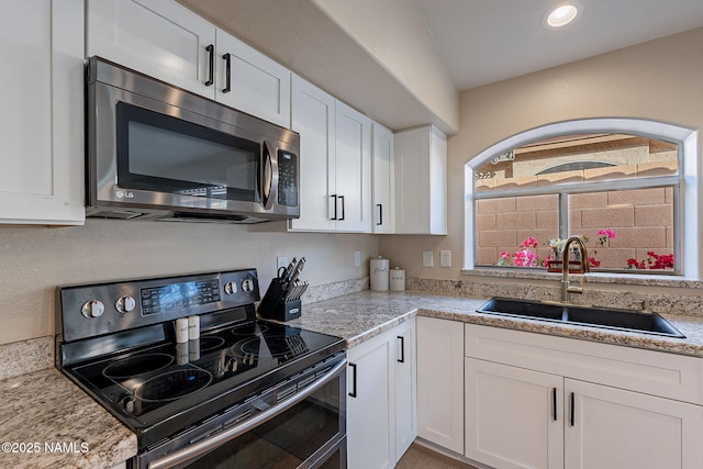 kitchen with white cabinets, sink, electric range, and light stone counters