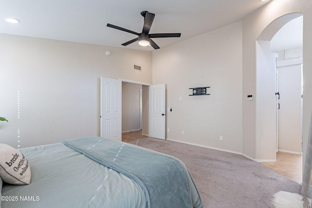 carpeted bedroom featuring ceiling fan and high vaulted ceiling