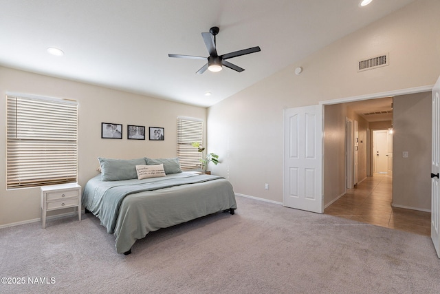 carpeted bedroom with ceiling fan and high vaulted ceiling