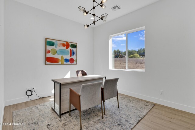 dining area featuring light hardwood / wood-style floors and a chandelier