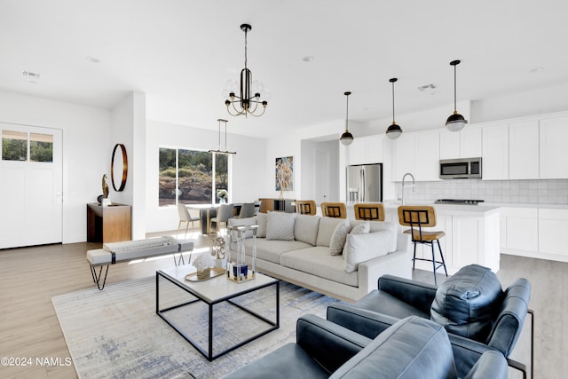 living room featuring light hardwood / wood-style floors, a chandelier, and a wealth of natural light